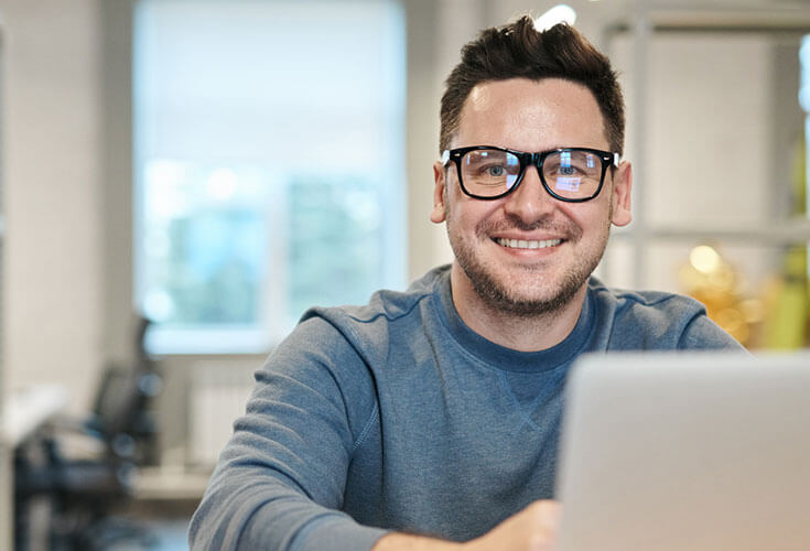 Persona con gafas frente a un computador