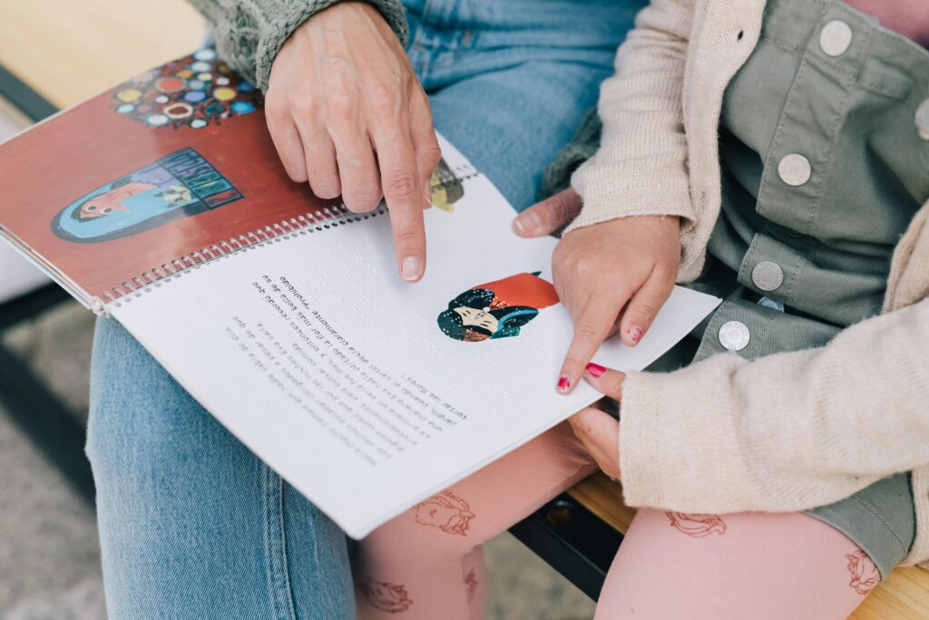 profesora leyendo en braille con su alumna